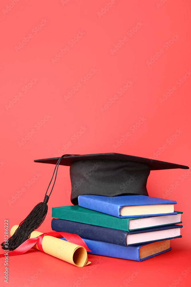 Graduation hat, diploma and books on color background