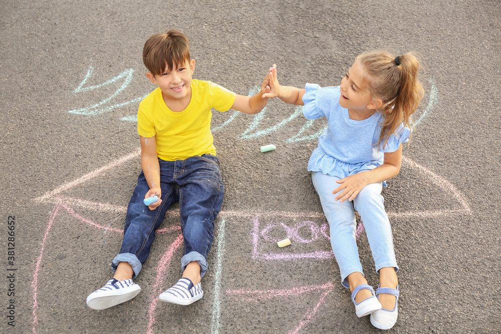 Little children sitting on chalk drawing of ship outdoors
