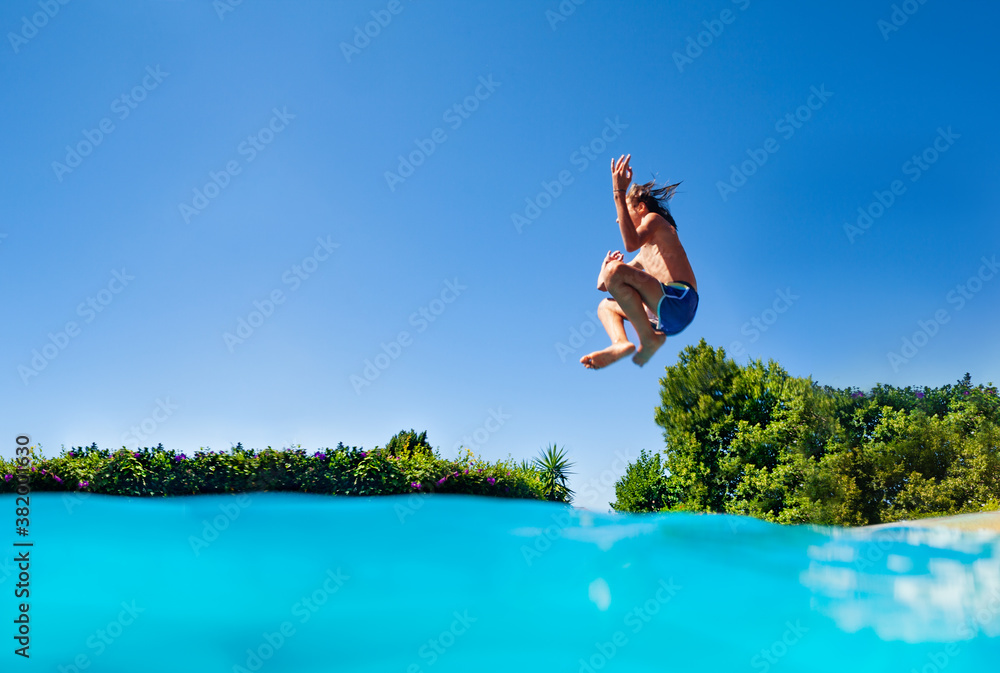 Profile photo of the boy jump high in action happy pose with lifted hands dive in the outdoor swimmi