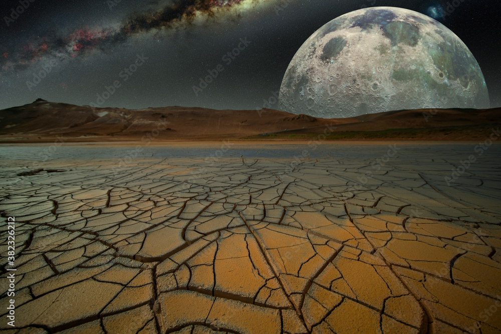 Fantastic night landscape with cracked earth  mountains and moon. Elements of this image furnished b