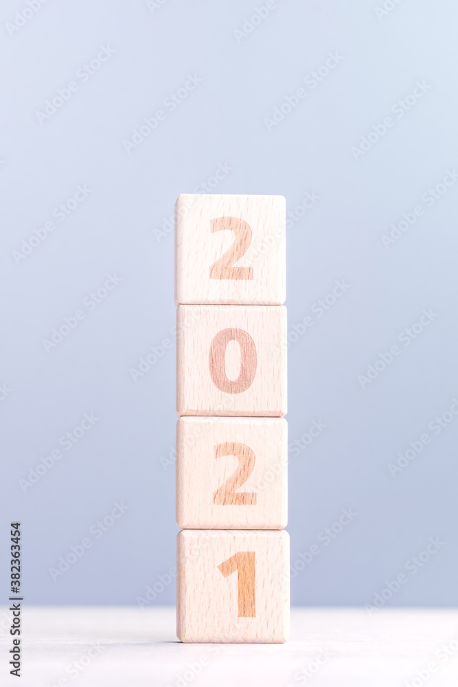 2021 New Year abstract design concept - Number wood block cubes isolated on wooden table and light m