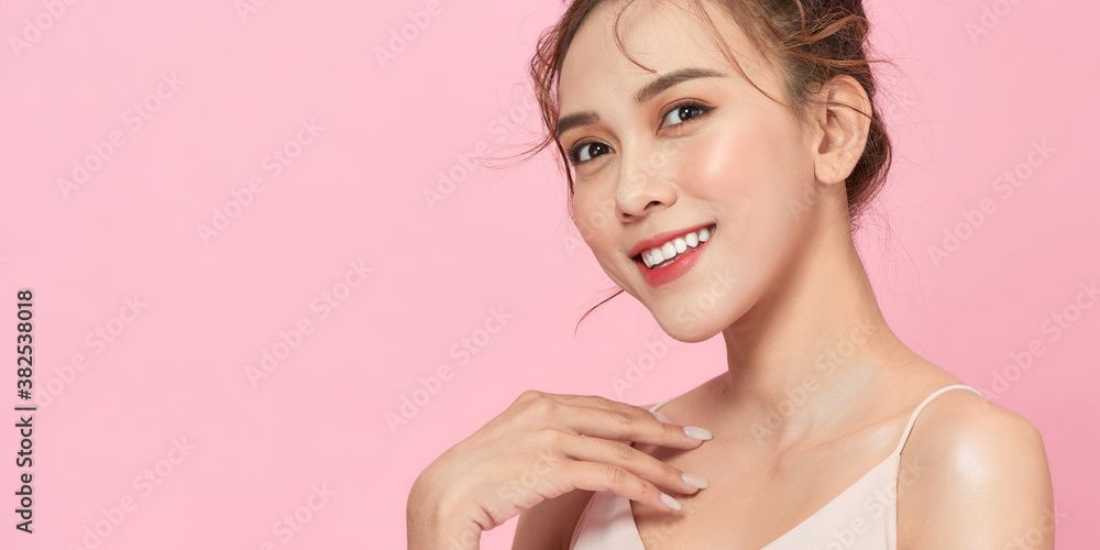 年轻的女模特摆出幸福的姿势，被隔离在粉红色的背景上