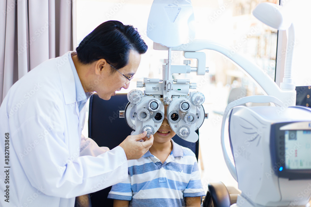 An Asian male doctor examines a childs vision. optometrists man are examining pediatric patients e