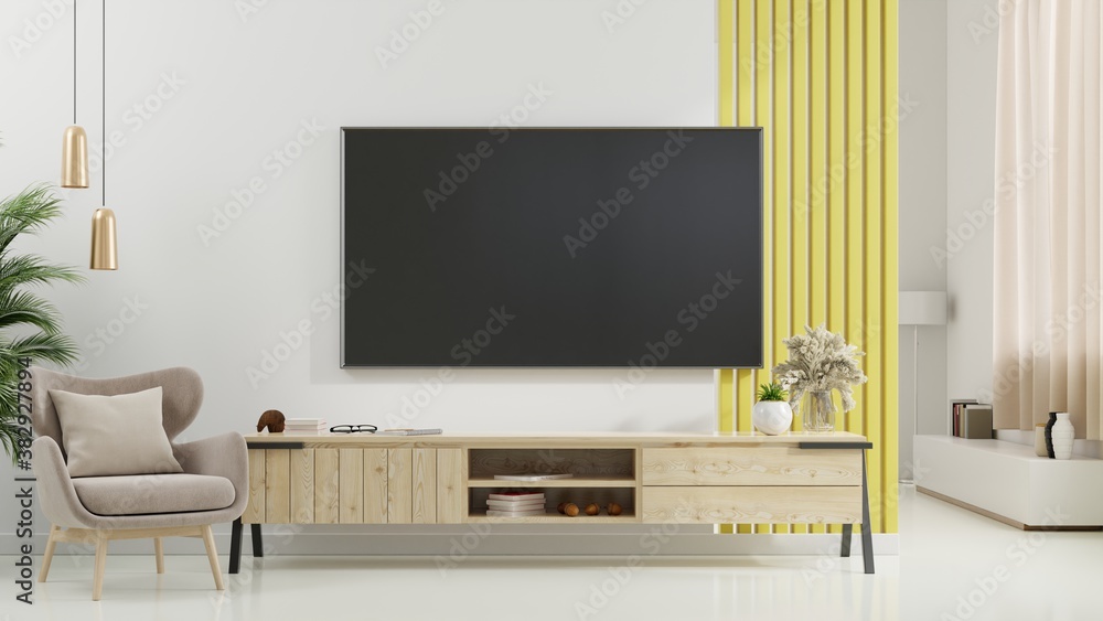 现代客厅橱柜上的电视，白墙背景上有扶手椅、灯、桌子、花草