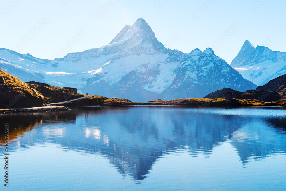 Bachalpsee lake in Swiss Alps mountains. Snowy peaks of Wetterhorn, Mittelhorn and Rosenhorn on back