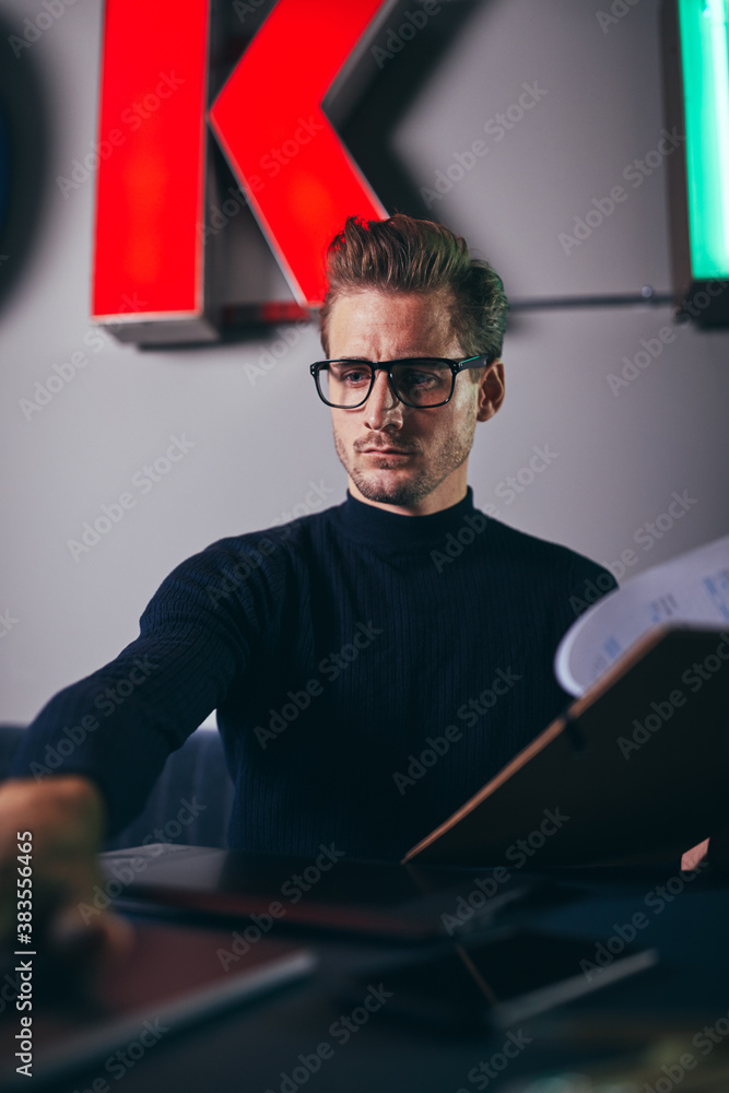 Focused businessman going over paperwork and working with a lapt