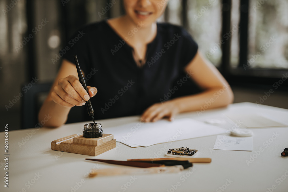 Woman writing a note with fountain pen.