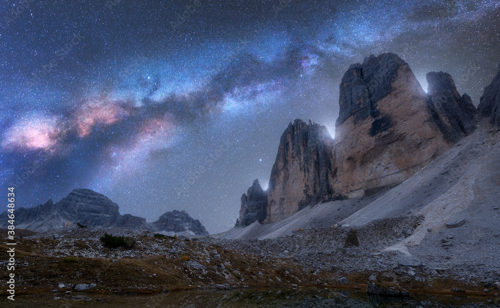 Milky Way over mountains at night in summer. Beautiful landscape with alpine mountains, blue sky wit