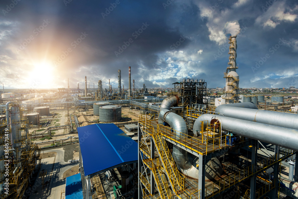 Industrial view at oil and gas refinery plant form industry zone with sunrise and cloudy sky, oil an
