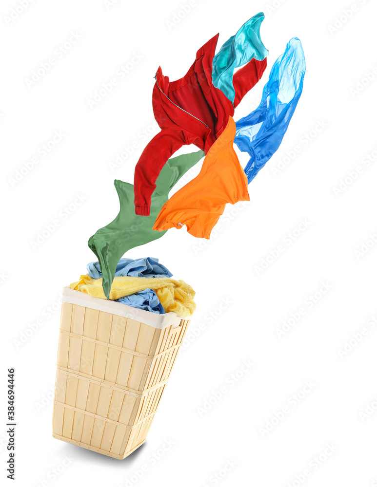 Laundry basket with flying clothes on white background