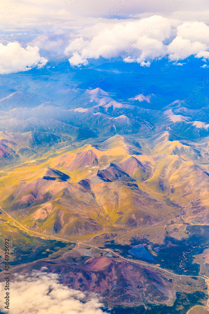 Aerial view above the clouds and colorful mountain on a sunny day.mountain view from airplane.