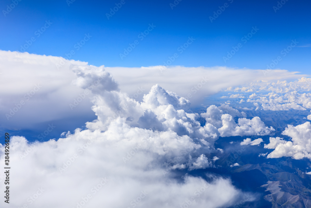 在阳光明媚的日子里俯瞰云朵和山峰。从飞机上俯瞰山景。