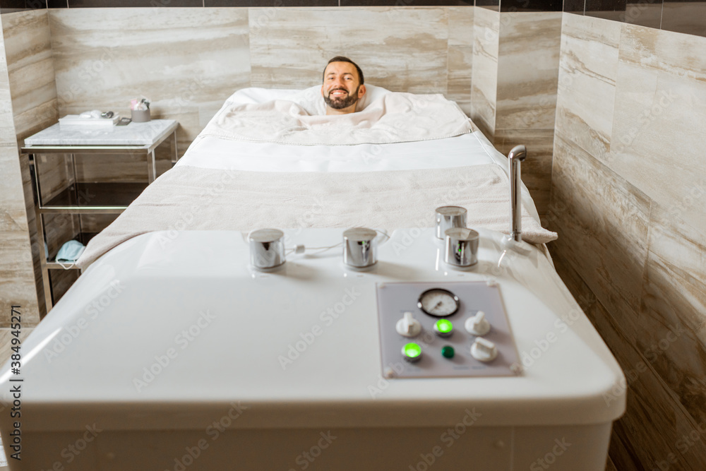 Man relaxing during a medical treatment at the bath filled with carbon dioxide at balneology room