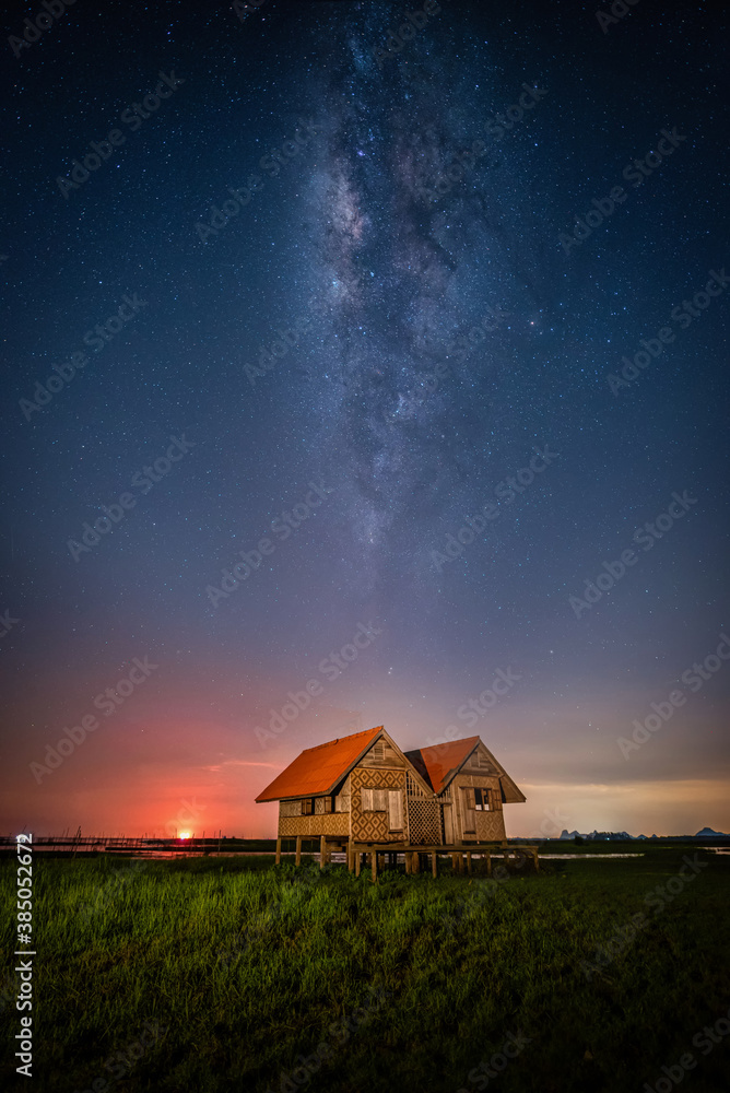 Landscape image of milky way over the abandoned twin house near Chalerm Phra Kiat road in Thale Noi,