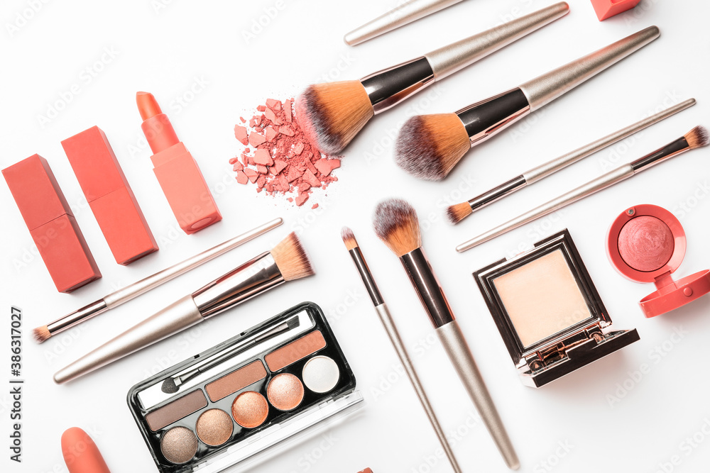 Set of makeup brushes with decorative cosmetics on white background