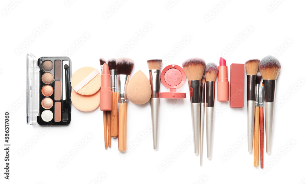 Set of makeup brushes with decorative cosmetics and sponges on white background