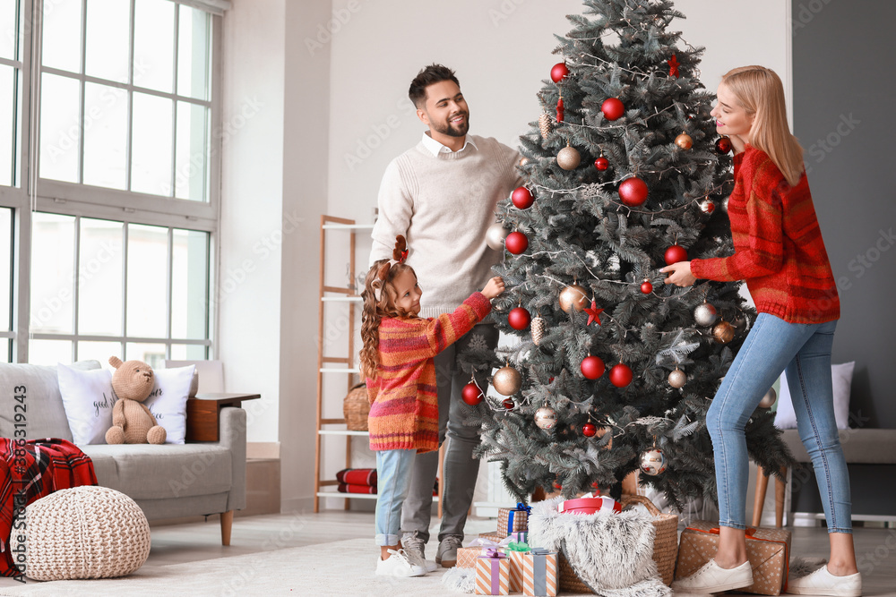 年轻家庭在家装饰圣诞树