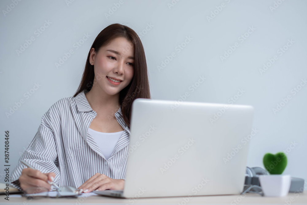 Young Asian women spend their free time using their laptop to educate themselves online and take not