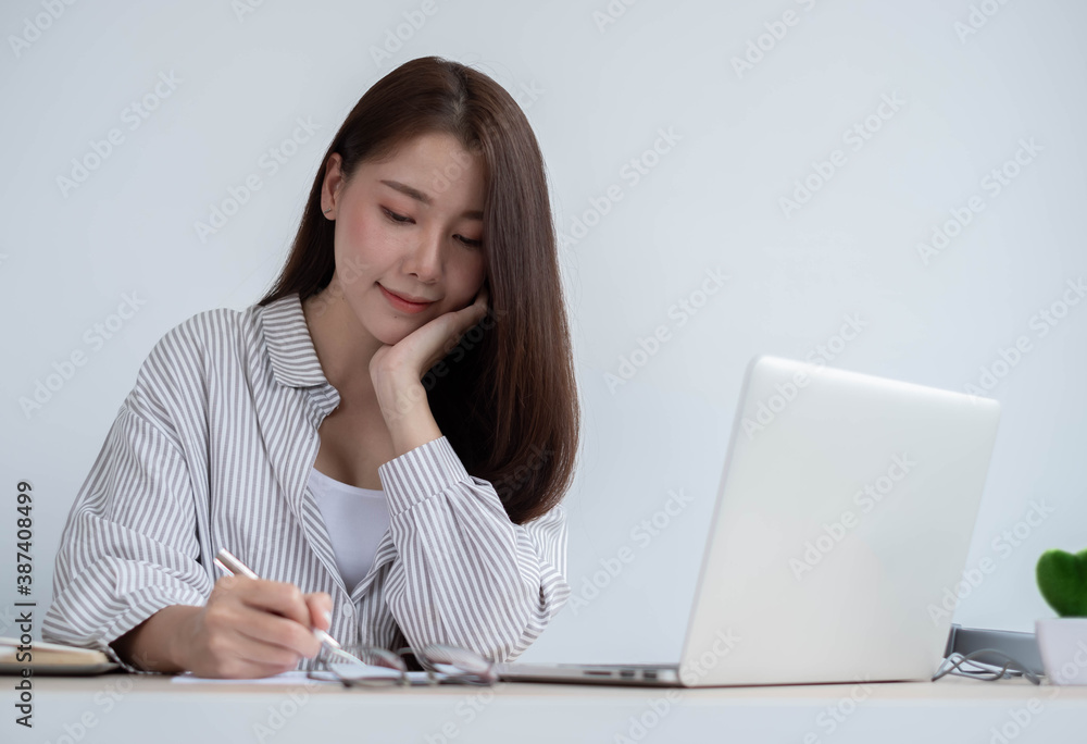 年轻的亚洲女性利用空闲时间使用笔记本电脑进行在线教育，而不使用