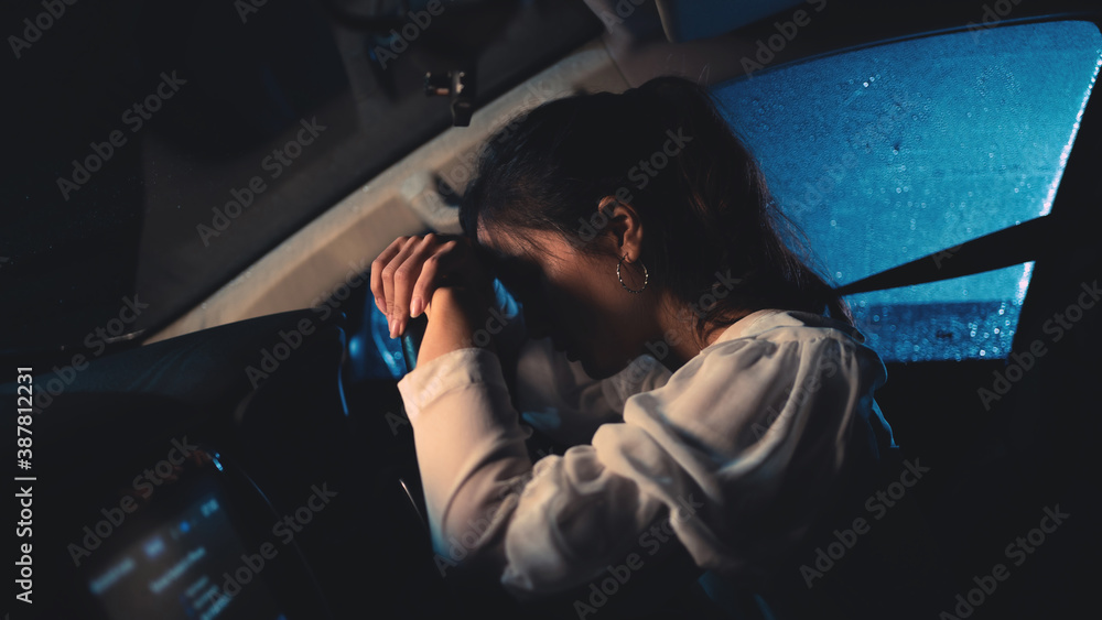 一名亚洲女子晚上独自开车。天在下雨。她很紧张。