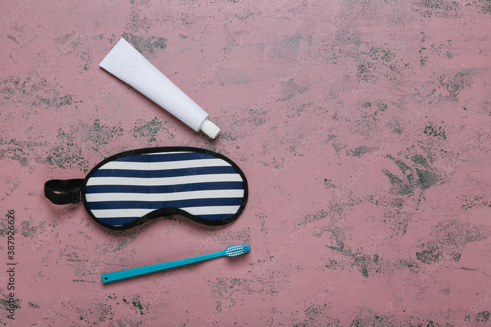 Tooth brush, paste and sleeping mask on color background