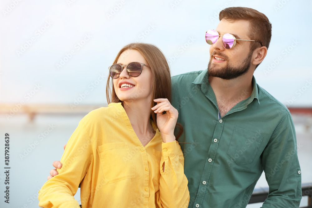 Young couple with stylish sunglasses outdoors