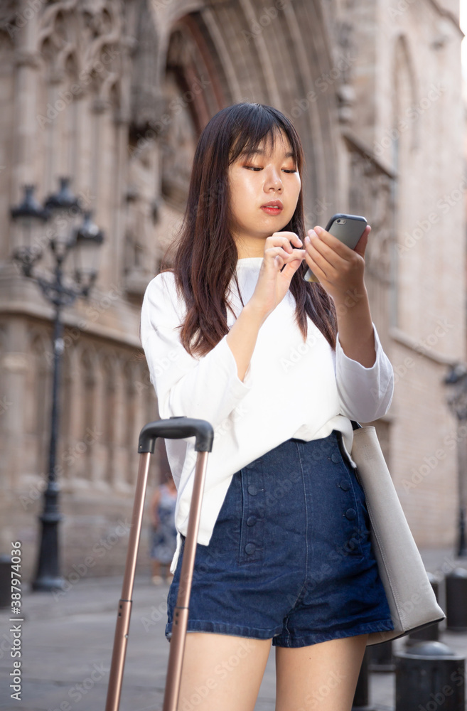 Young chinese female is looking up the way in phone by using gps. High quality photo