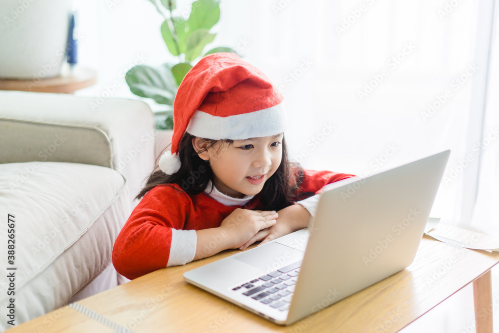 Asian girl with santa hat on christmas holidays party.Happy girl talking video cameara on laptop.Tec