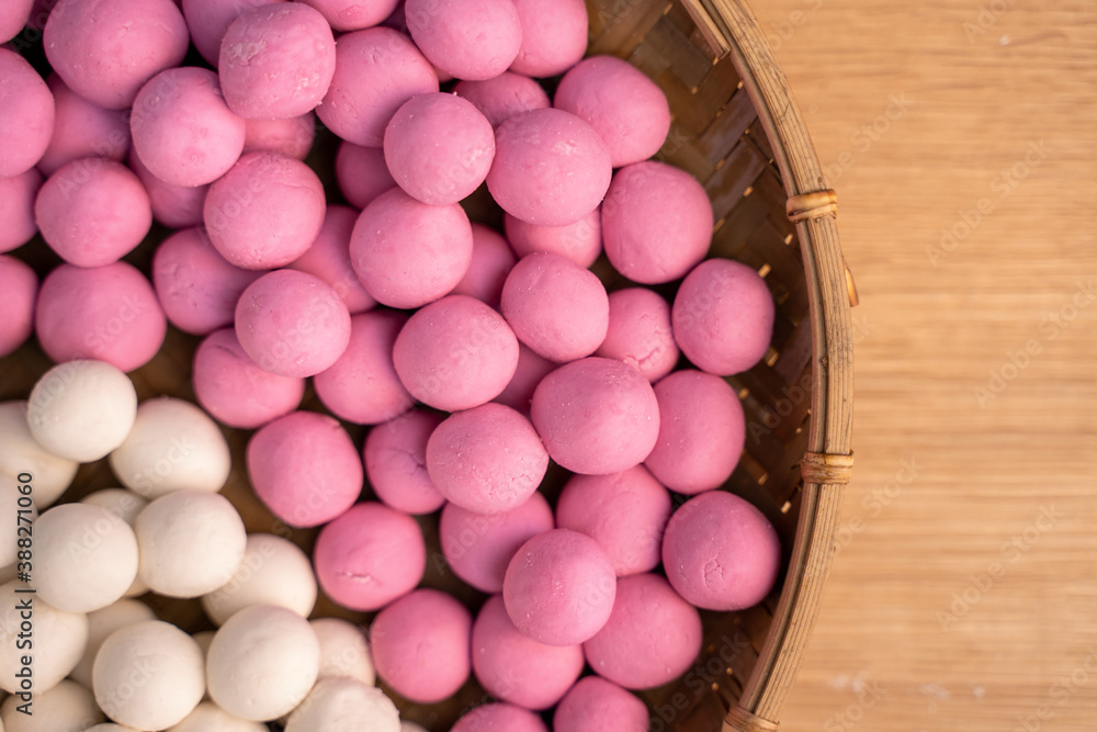 Raw little tangyuan in a sieve over wooden table.