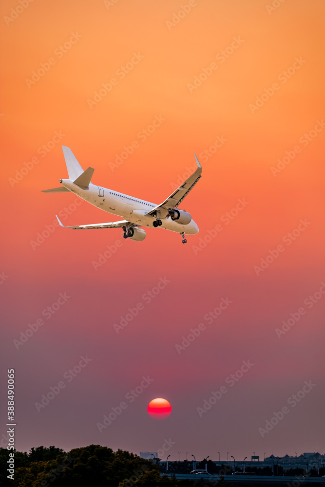 商业飞机在五彩缤纷的日落中飞越云层。旅行、度假和商业理念。