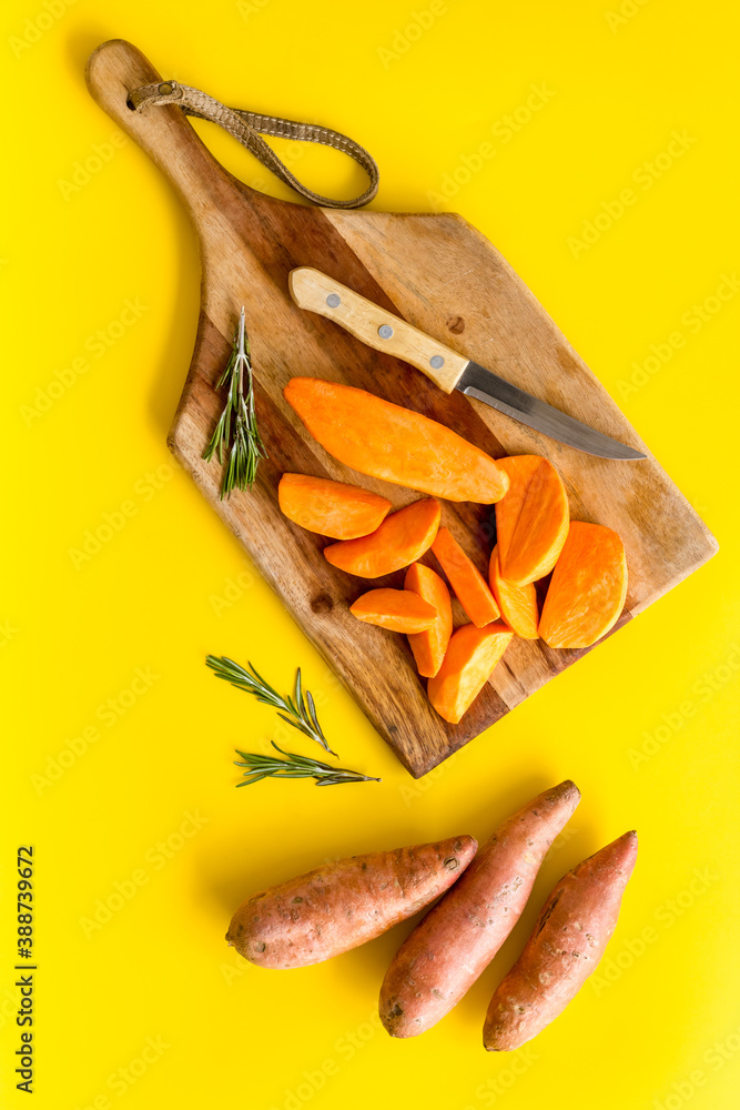Raw orange sweet potato on cutting board, top view