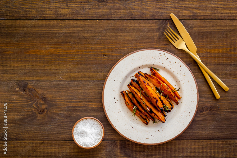 Pile of sweet potato fries with herbs on a plate, top view