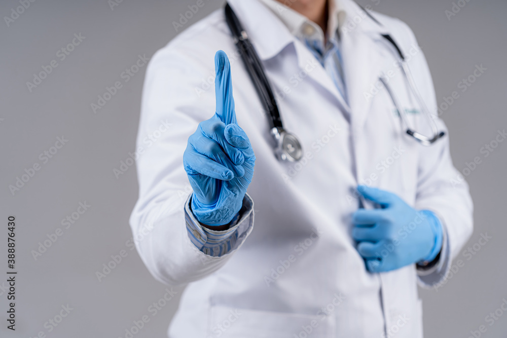 Selective focus on doctor`s hands in blue medical gloves. Cropped photo of a medic in scrubs. Health