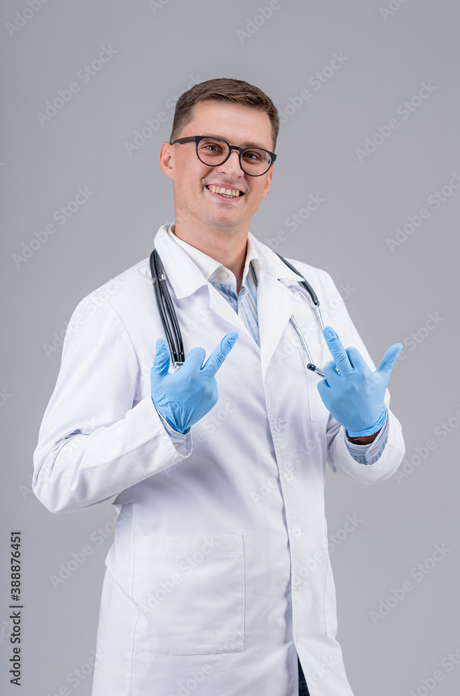 Doctor in scrubs and stethoscope showing middle finger isolated on grey background. Selective focus.