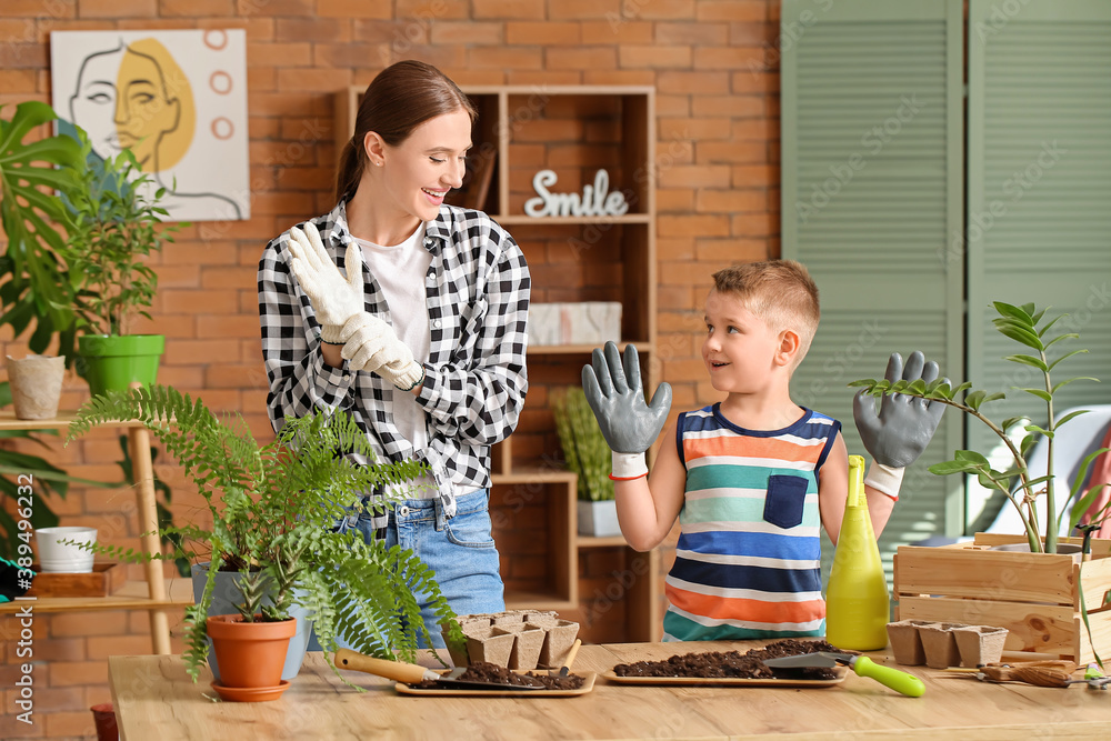 Young mother with son setting out plants at home