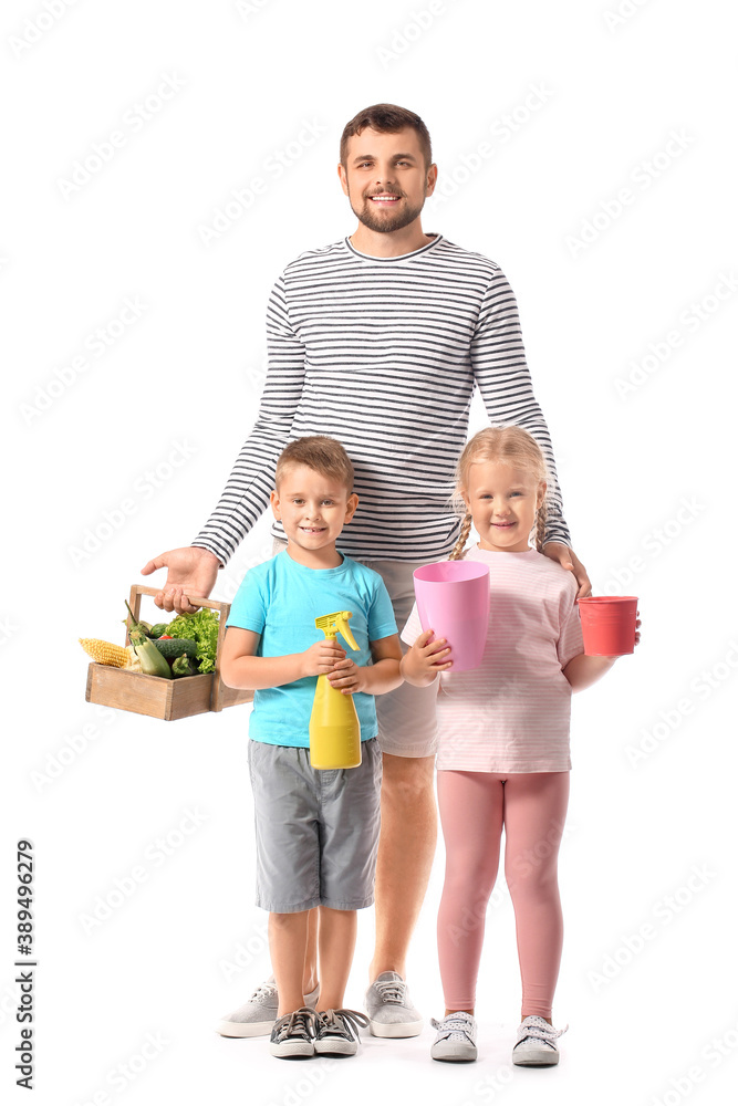 Young family with gardening supplies and harvest on white background