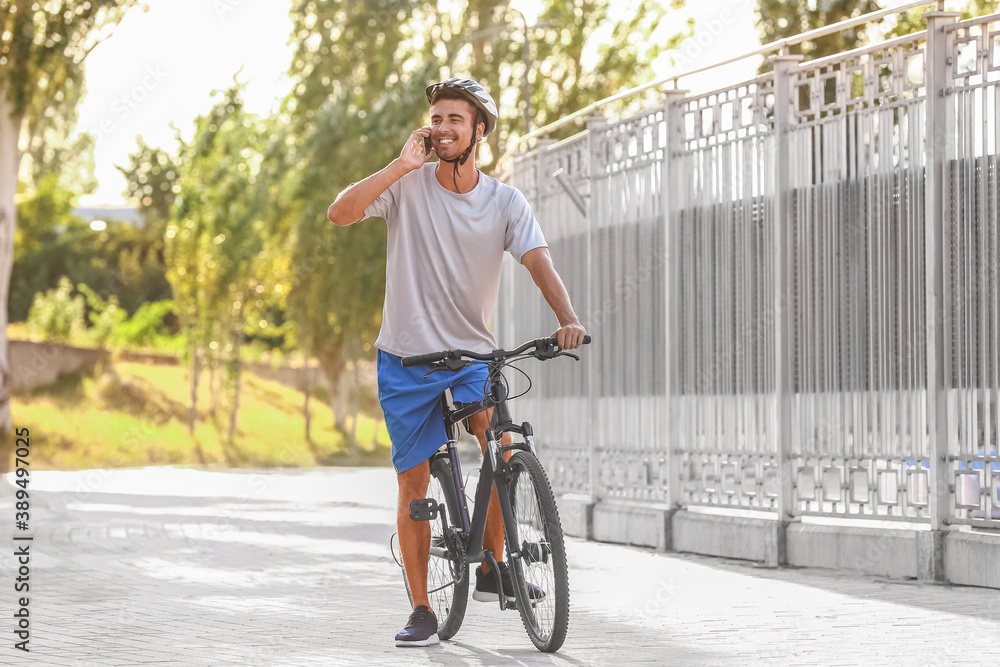 Male cyclist talking by phone outdoors
