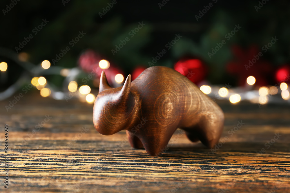 Figurine of bull as symbol of year 2021 on wooden table