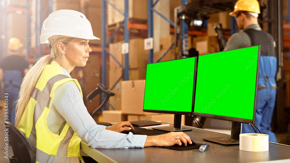 Professional Female Worker Wearing Hard Hat Uses Computer with Green Chroma Screen Mock-up in the Re