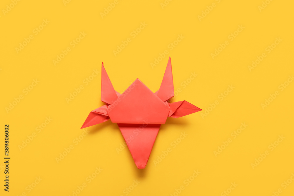Origami bull as symbol of year 2021 on color background