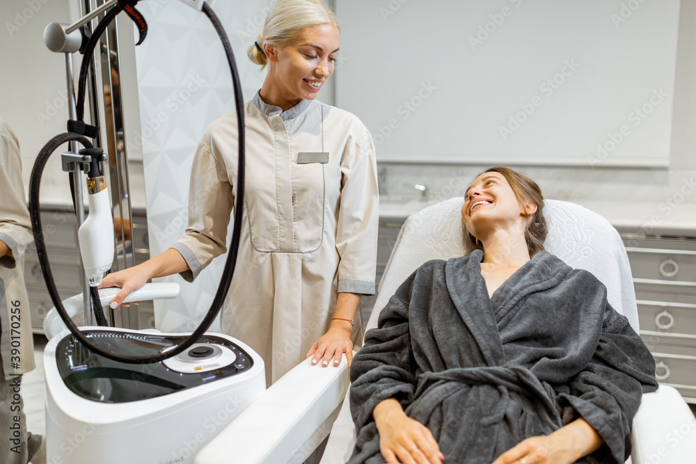 Young woman client with a doctor during a facial rejuvenation treatment at medical SPA office. Conce