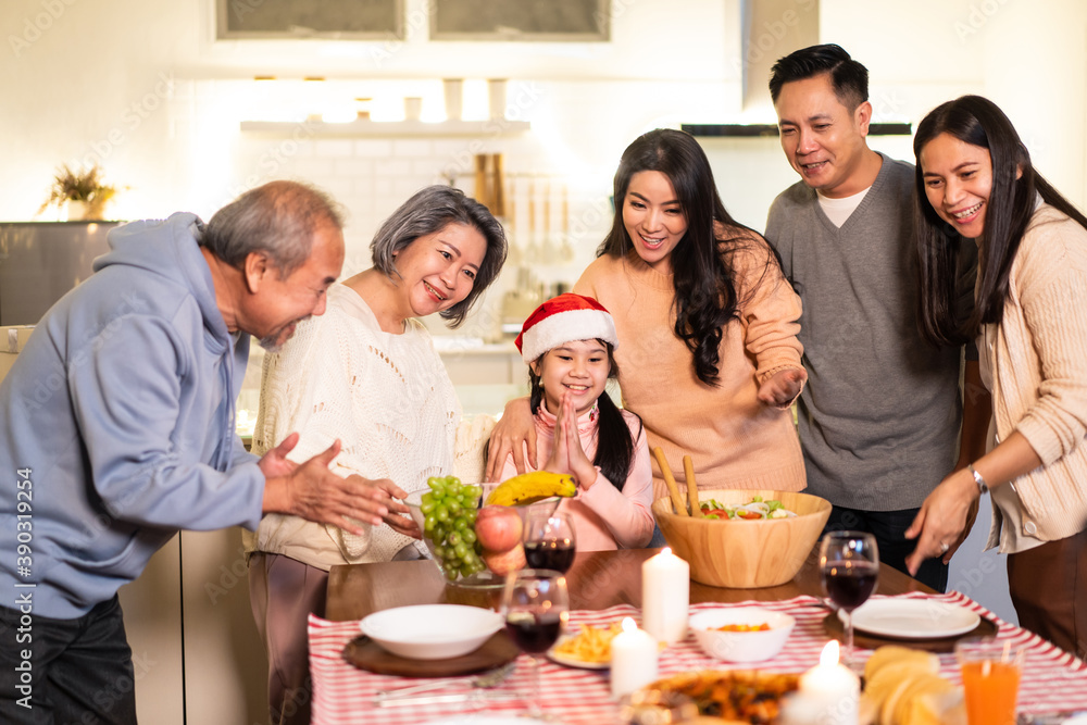 亚洲大家庭在为圣诞派对准备食物时唱歌