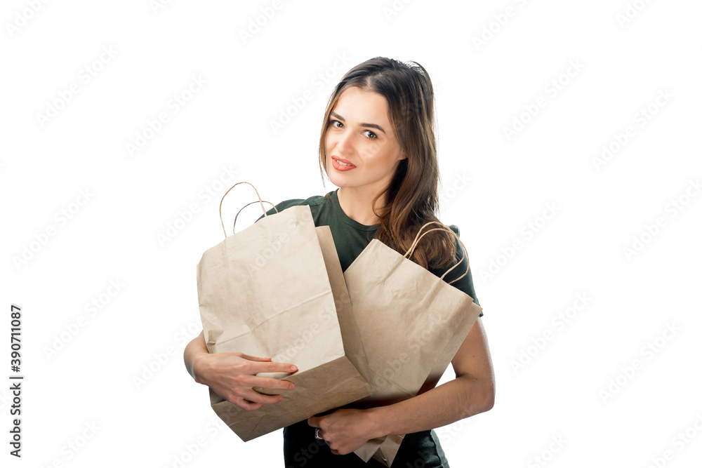 女人拿着两个白色背景的杂货购物袋。前面是纸袋。后面是隔离的。