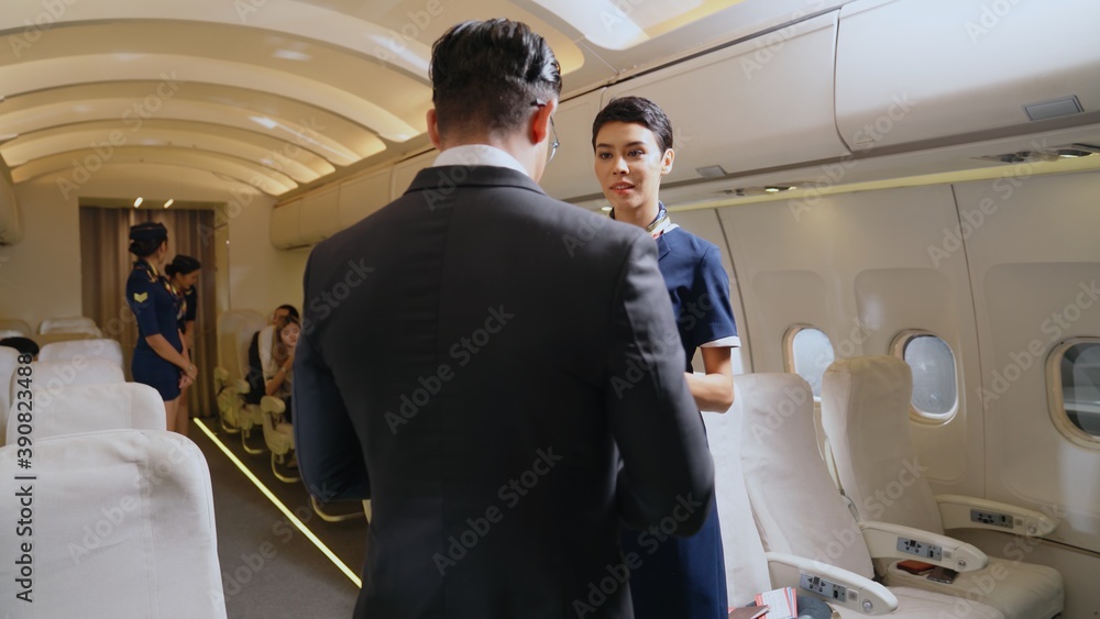 Cabin crew greeting passenger in airplane . Airline transportation and tourism concept.