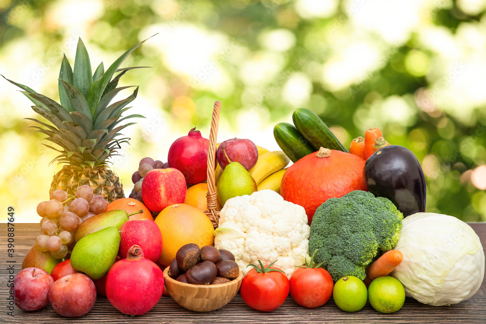 将蔬菜和水果苹果、葡萄、橙子和香蕉与胡萝卜放在木篮子里，