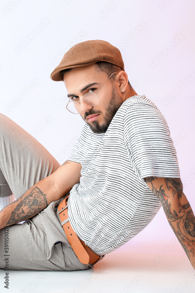 Fashionable young man on light color background