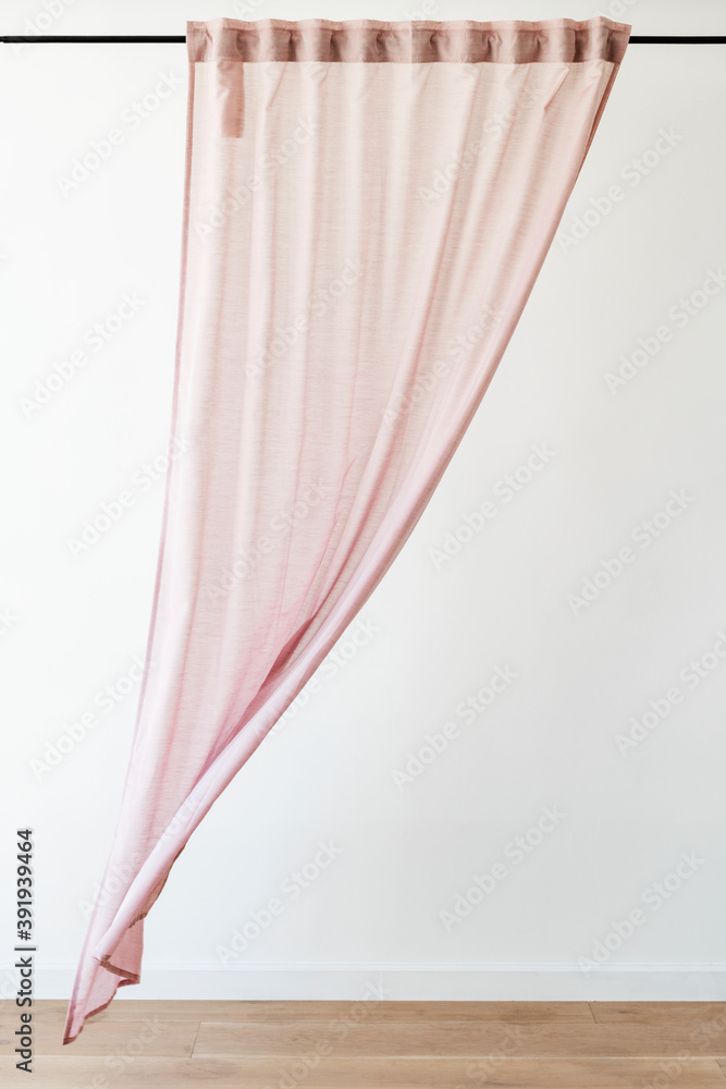 悬挂在窗帘杆上的粉红色窗帘