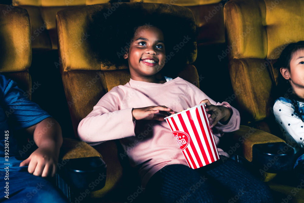 三个孩子玩得很开心，喜欢在电影院看电影