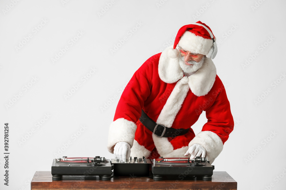酷酷的圣诞老人DJ在灰色背景下播放音乐