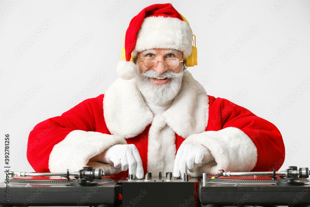 酷酷的圣诞老人DJ在灰色背景下播放音乐